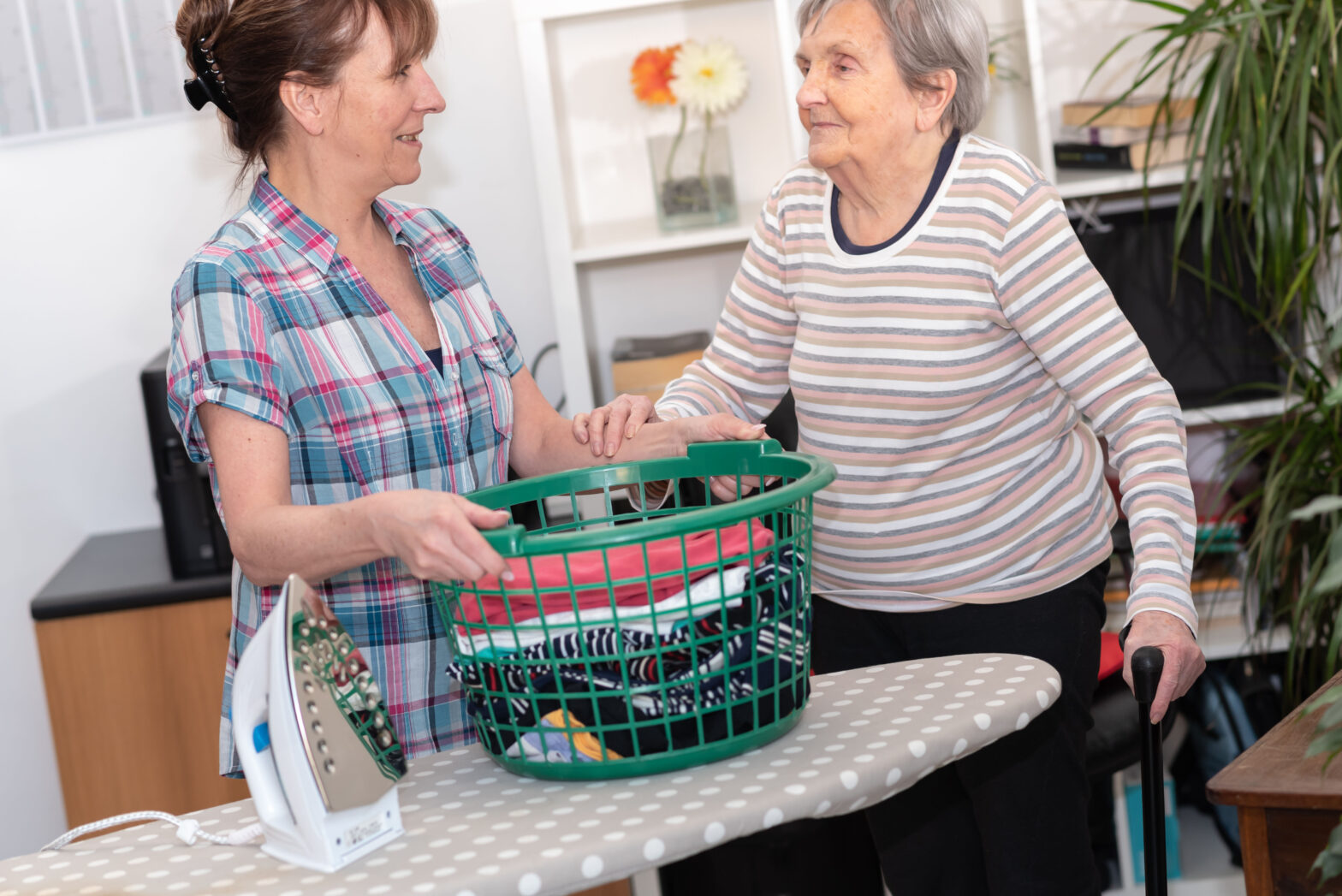 Frau hilft älterer Dame bei der Wäsche